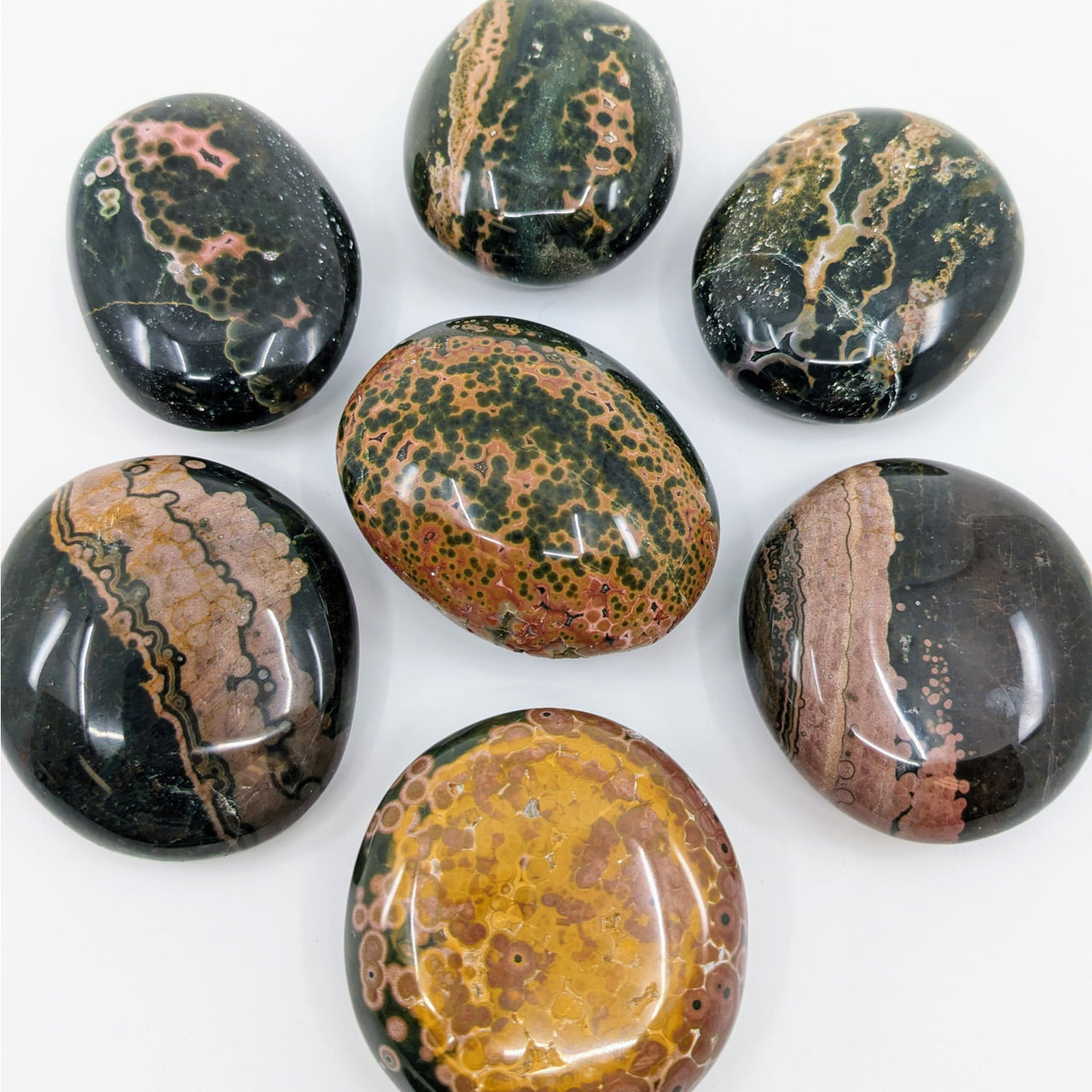 Six colorful Kabamby Ocean Jasper Pebbles arranged in a circle