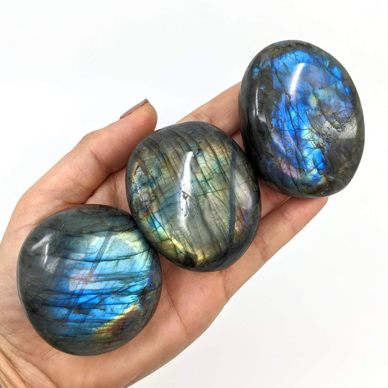 Labradorite Pebble Palm Stone #SK7434: Hand holding three blue and green labradorite stones