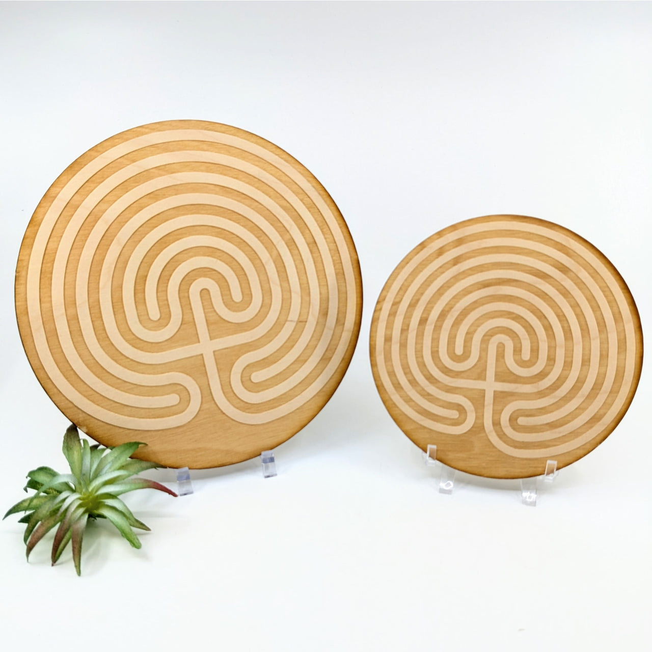 Two circular wooden boards featuring labyrinth patterns for Alderwood Etched Crystal Grid