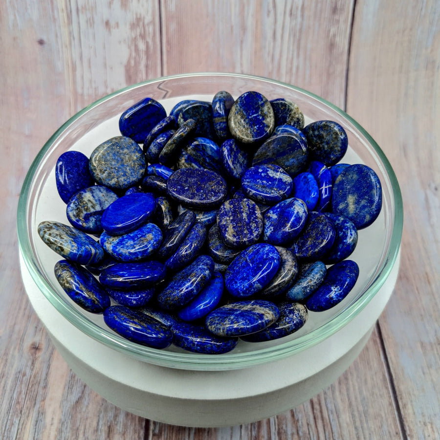 A bowl of Lapis Lazuli 1’ palm stones, beautifully crafted and vibrant in blue