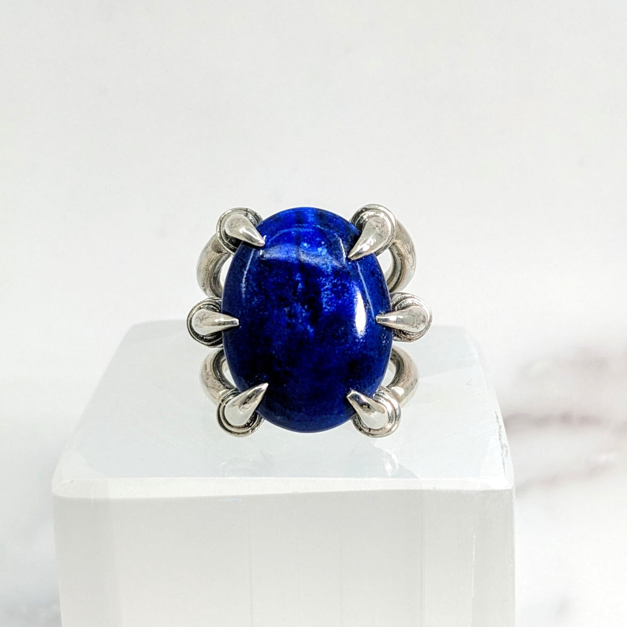 Close-up of Lapis Lazuli Jumbo S.S. Claw Ring Sz. 9.5 with blue stone on white surface