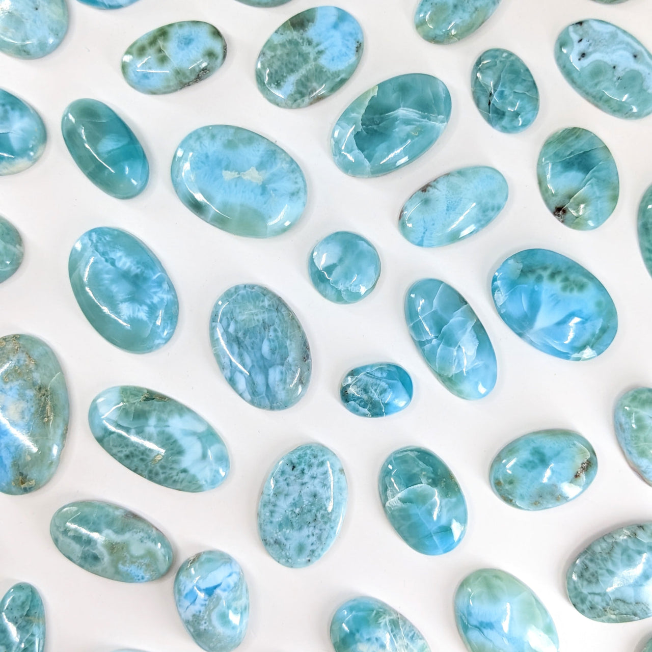 Close-up of blue Larimar Cabochon stones on a white surface for jewelry making. #LV2450