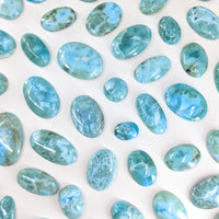 Thumbnail for Close-up of blue Larimar Cabochon stones on a white surface for jewelry making. #LV2450