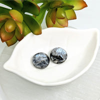 Thumbnail for Two black and white marbled Larvikite 18mm disc beads in a white dish