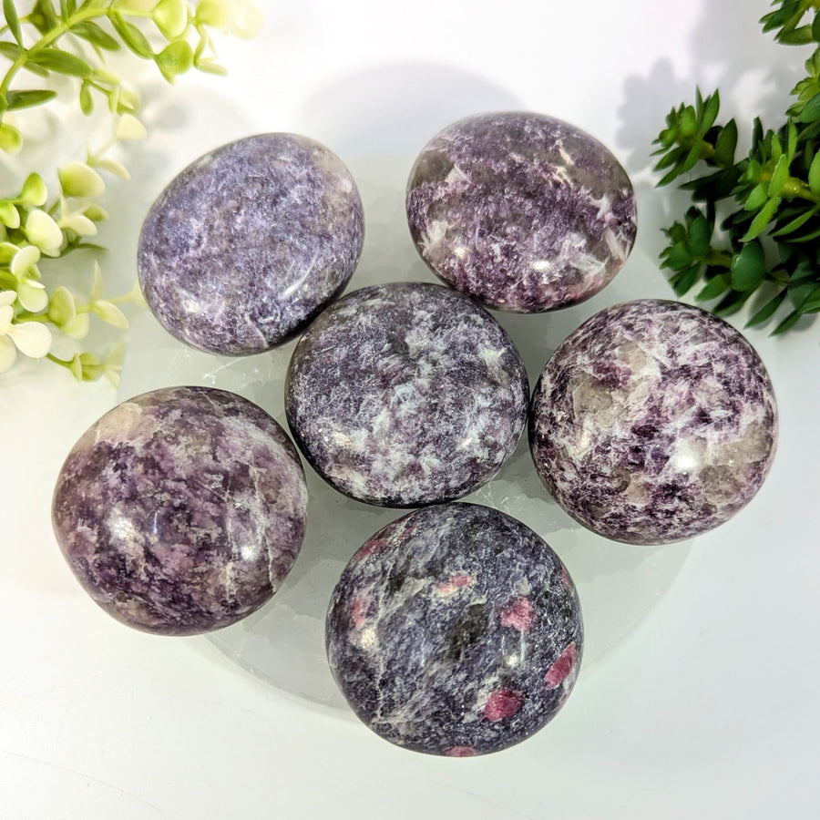 Six polished lepidolite 1.9 to 2 inch pebble spheres in purple and gray with swirling patterns and pink inclusions