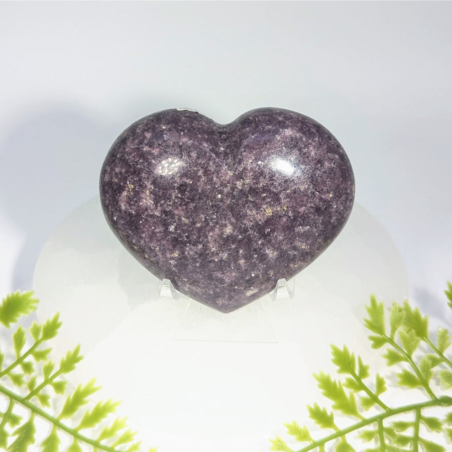 A polished purple lepidolite 3 inch heart gemstone with a glittering surface perfect for jewelry and crystals collection