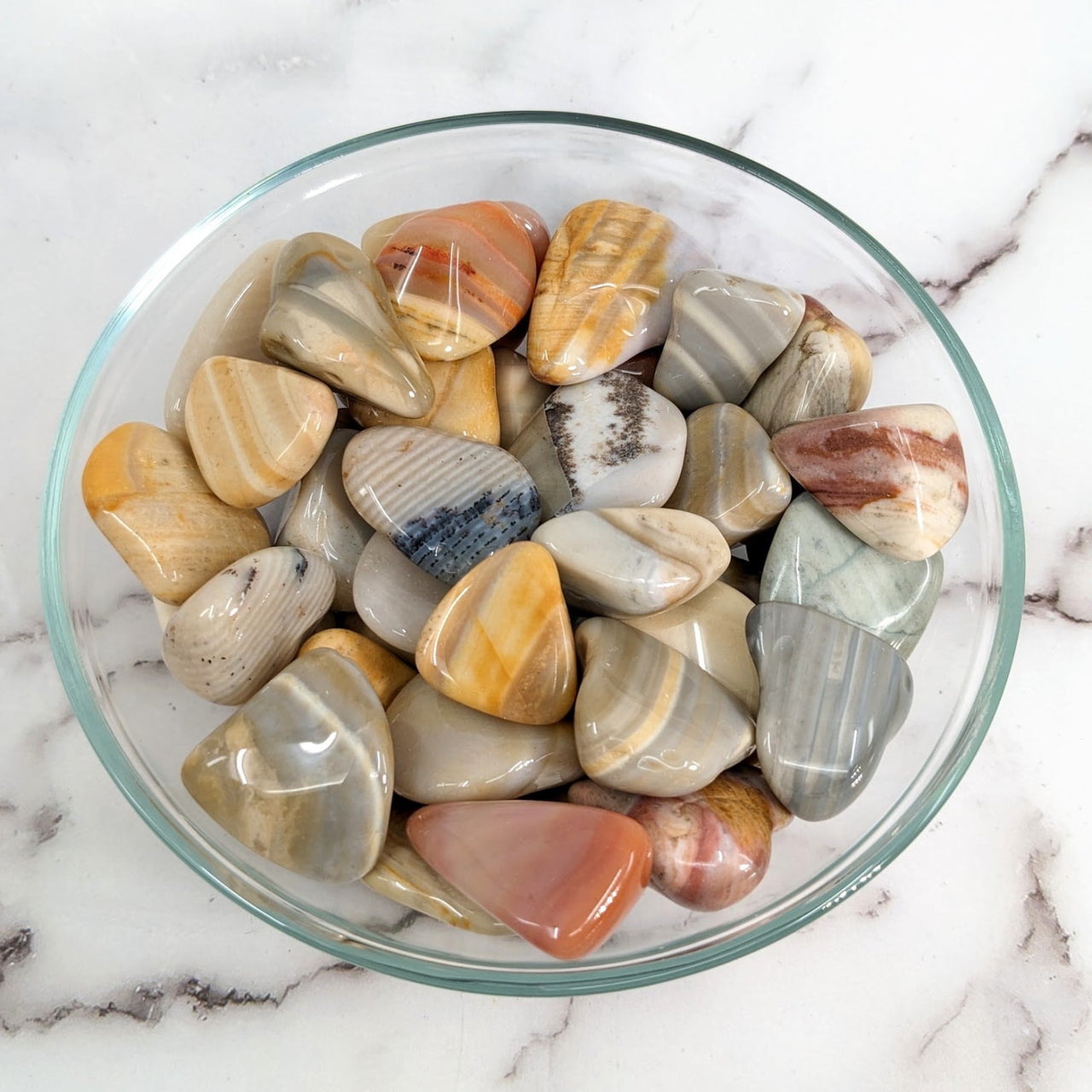 A bowl filled with various colored Madagascar Flint 1-1.5’ tumbled stones #LV1634