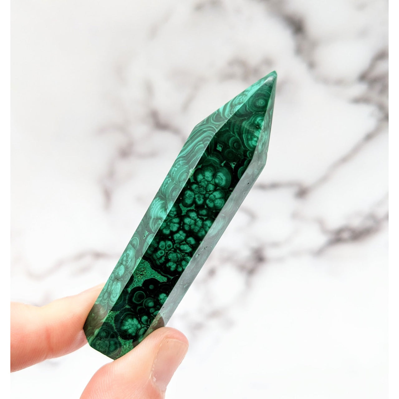 Hand holding a green malachite stone tower from the Malachite 2.7 - 3.1’ collection #LV2570