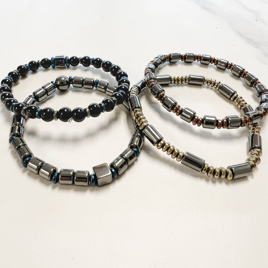 Four beaded hematite gemstone bracelets including Onyx and Tigers Eye sitting together