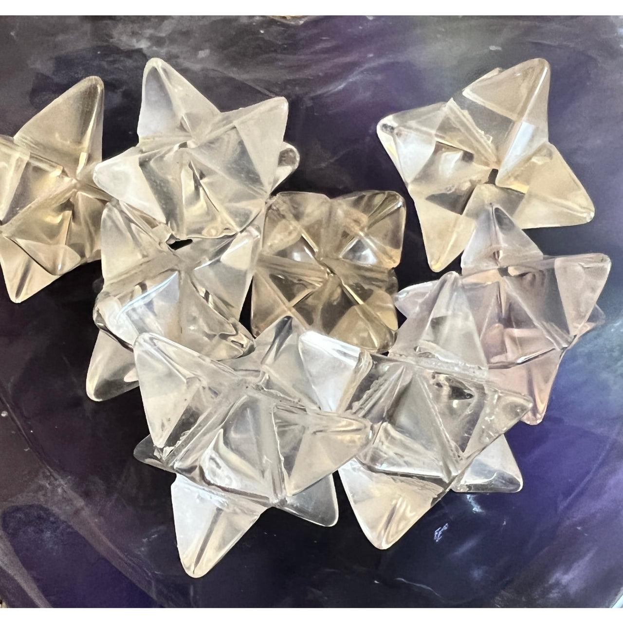 Mini Quartz Merkaba Crystal Carving #M024D: Clear glass stars on a purple background