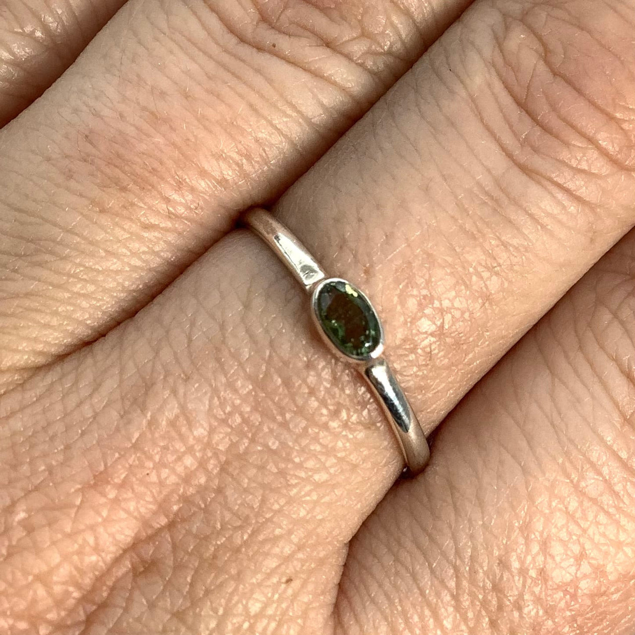 Woman’s hand wearing Moldavite Faceted Oval Cut, Sterling Silver Ring #SK2619