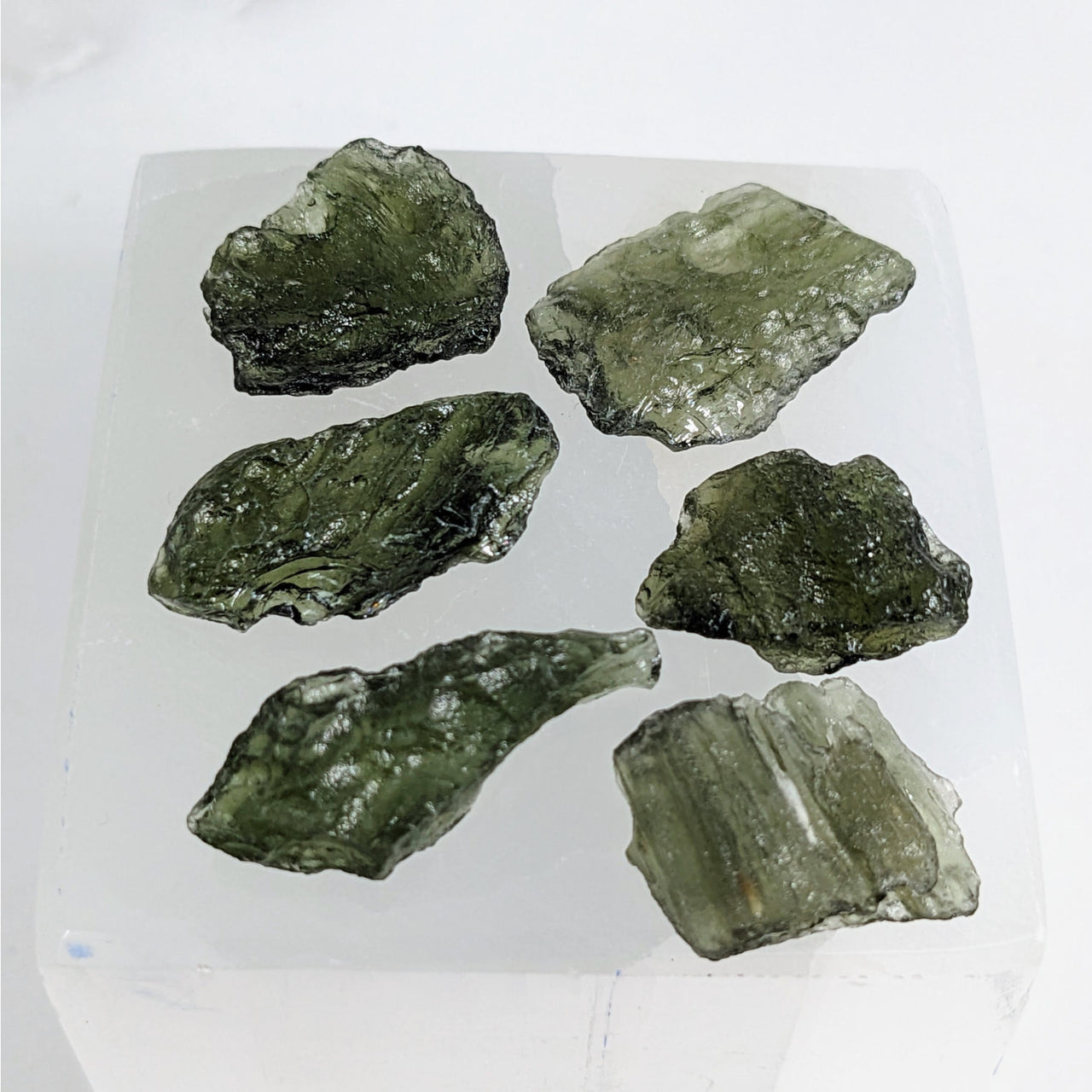 Moldavite Raw Large 1.1-1.3gm Chunk Czech Rep. #LV3469 green crystals on white surface