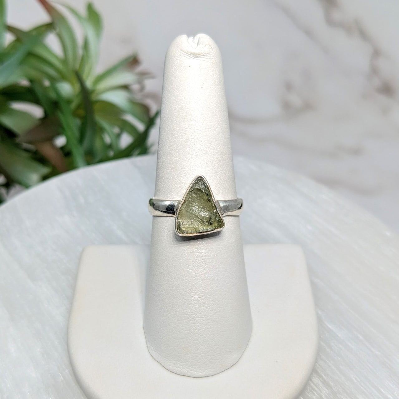 Silver ring with triangular green Moldavite stone in size 7.25 displayed on a jewelry page