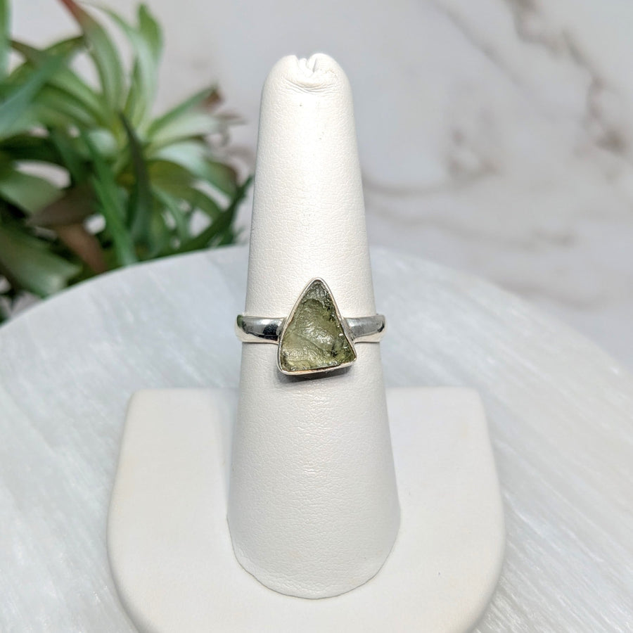 Silver ring with triangular green Moldavite stone in size 7.25 displayed on a jewelry page