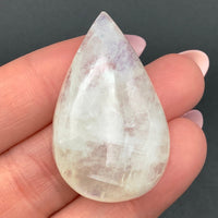 Thumbnail for Close-up of a person holding a Moonstone Blue Flash Cab white quartz stone (11g)