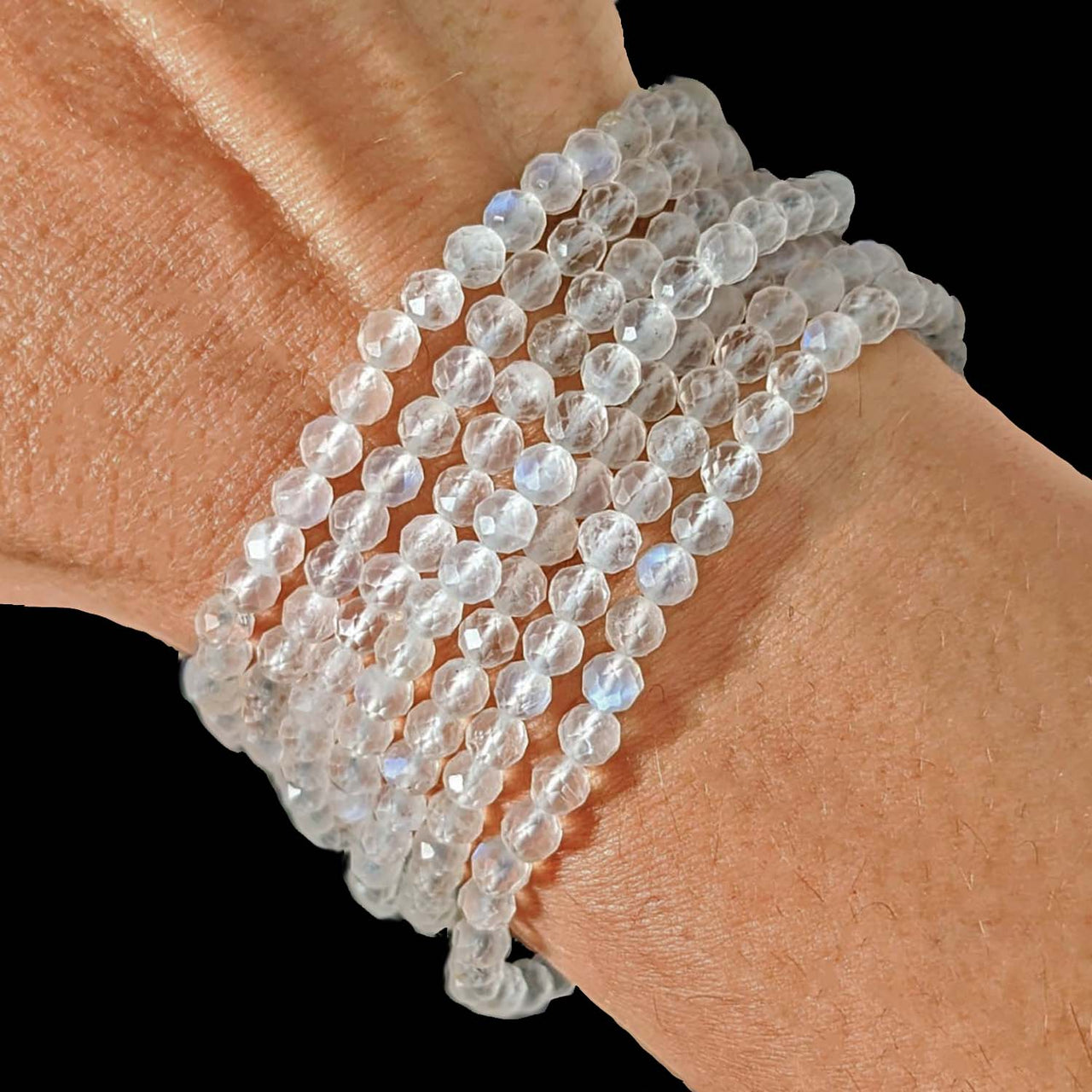 Woman’s hand showcasing a faceted 4mm bracelet with white quartz beads, perfect for rewards