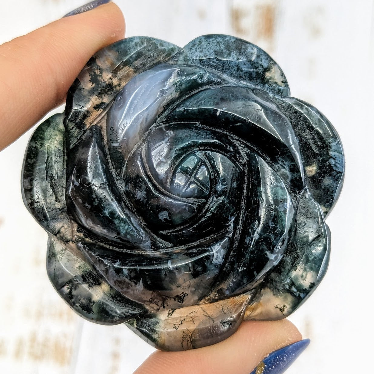 Hand holding a large black rose from Moss Agate 2.1’ Flower Carving #LV1977