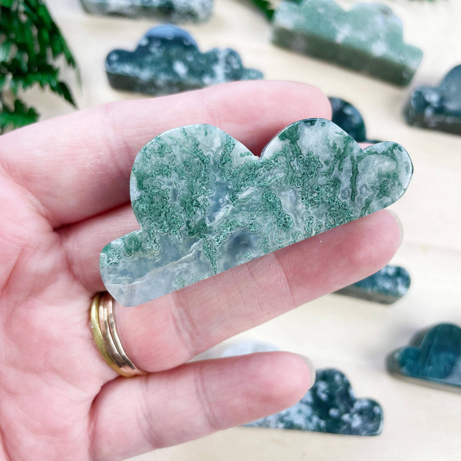 Hand holding moss agate cloud carving LV9099 with green white swirls