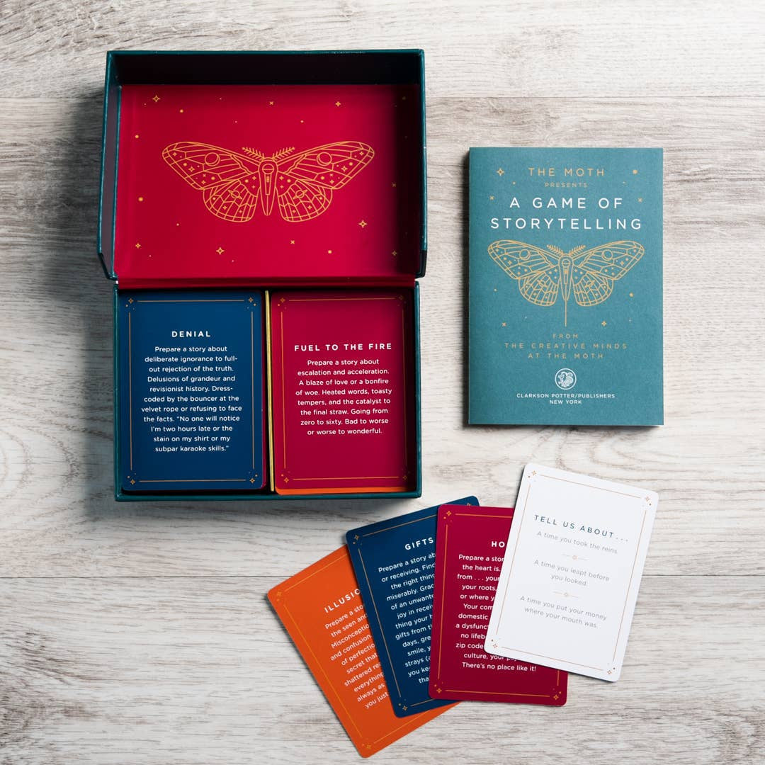 The moth presents storytelling game red and teal box with gold embossed moth and colorful story cards inspired by crystals