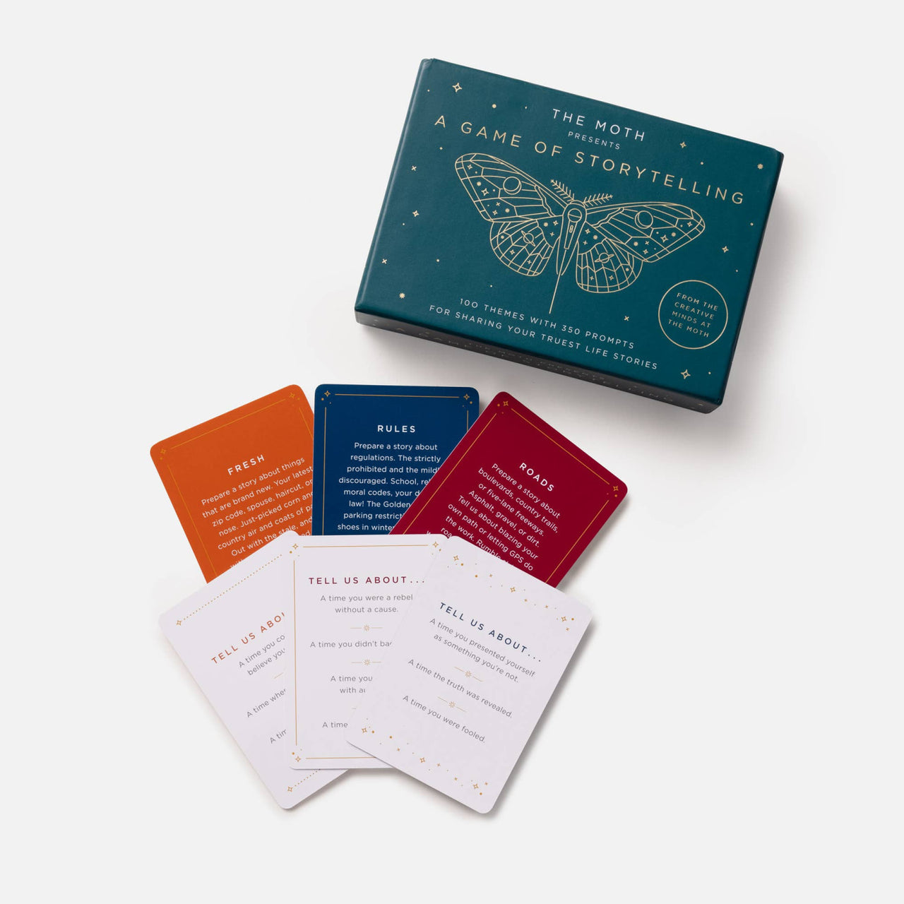 Teal rectangular storytelling game box with white moth line art and gold foil accents featuring gemstones theme