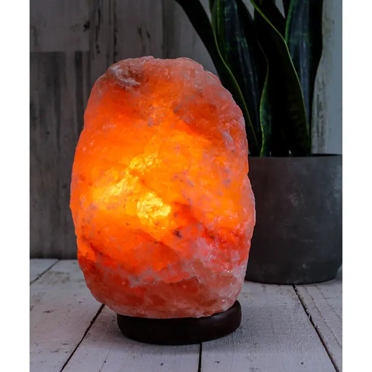 Close-up of a Himalayan salt lamp on a wooden table - Natural PINK Himalayan Salt Lamp