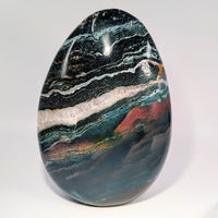 Polished 7-inch ocean jasper egg with green, black, white, red swirls