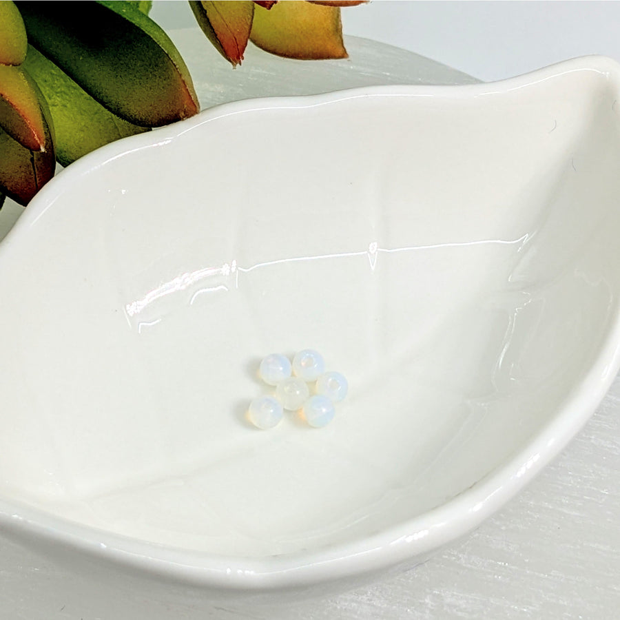 White ceramic leaf dish with floral design, perfect for showcasing Opalite 4mm small round beads