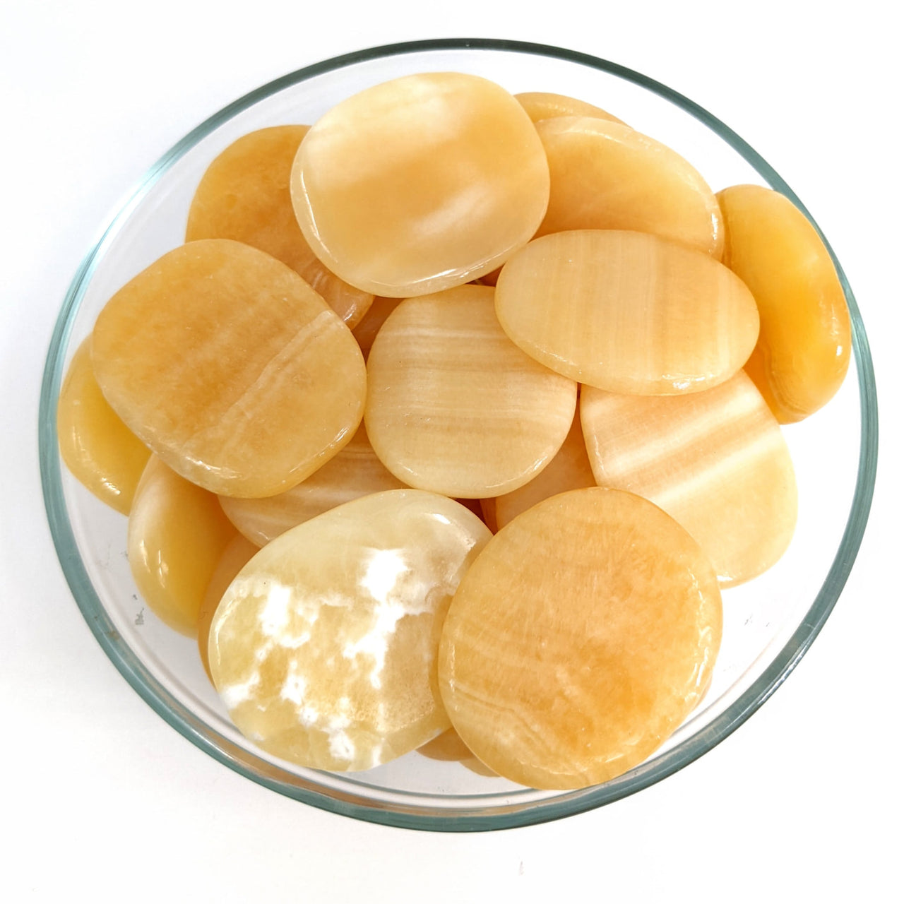 Sliced potatoes in a bowl next to Orange Calcite Palm Stones for sale