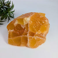 Rough translucent orange calcite specimen for centering purposes in crystal displays