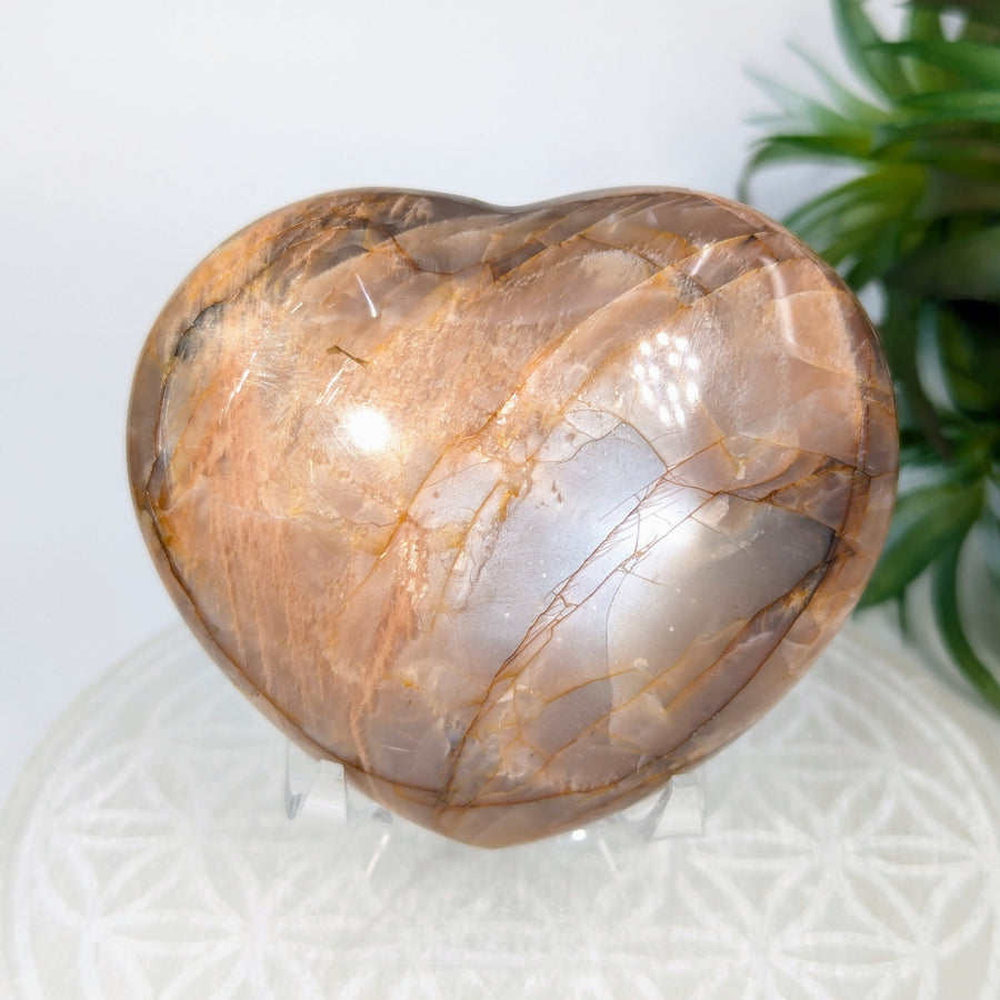 Polished peach moonstone heart gemstone in a 3-inch size for jewelry or display