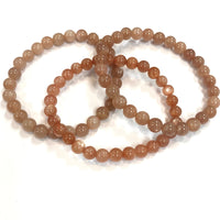 Thumbnail for Three interlocked peach moonstone bracelets showcasing their elegant design and color