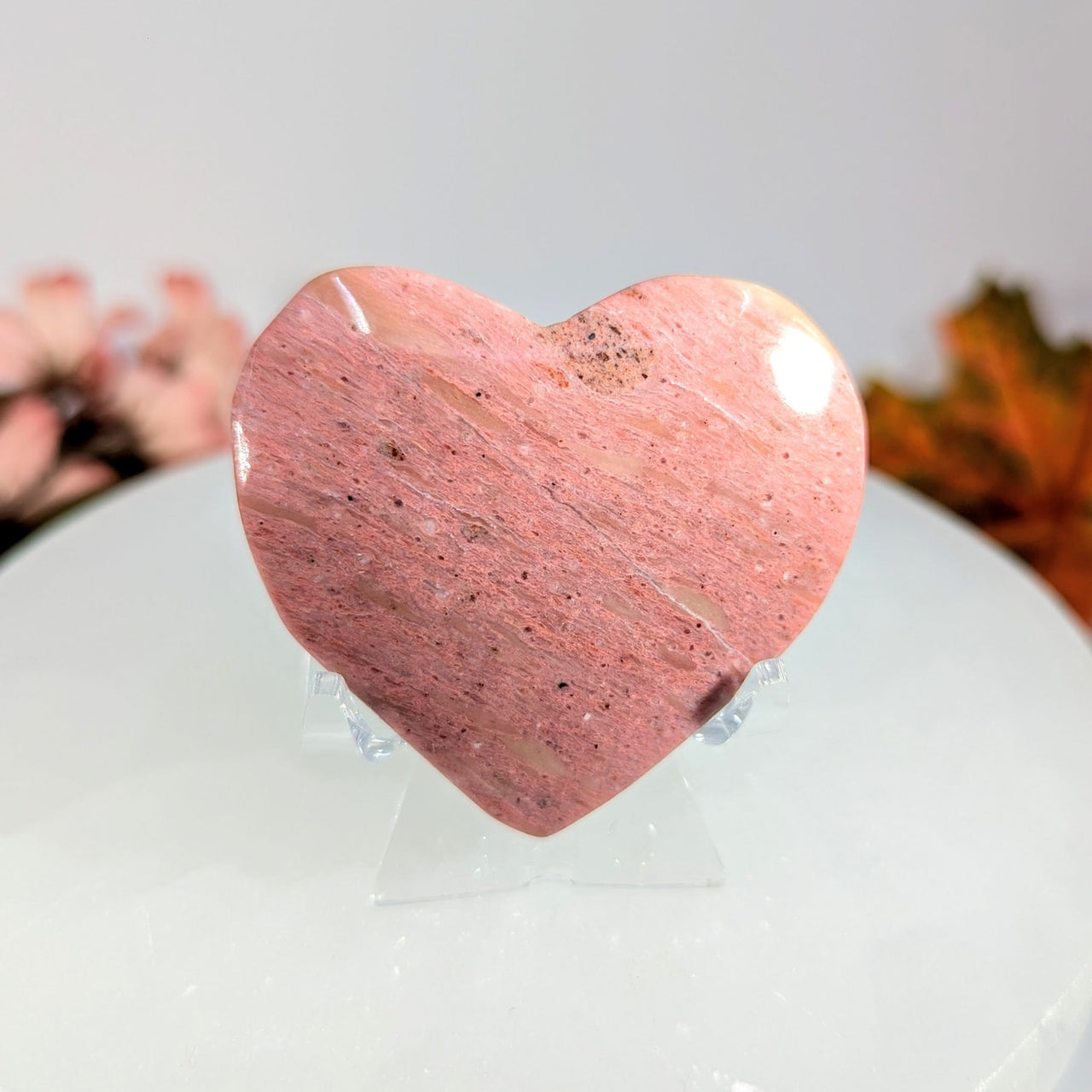 Pink rhodonite heart-shaped stone on display stand BC0093