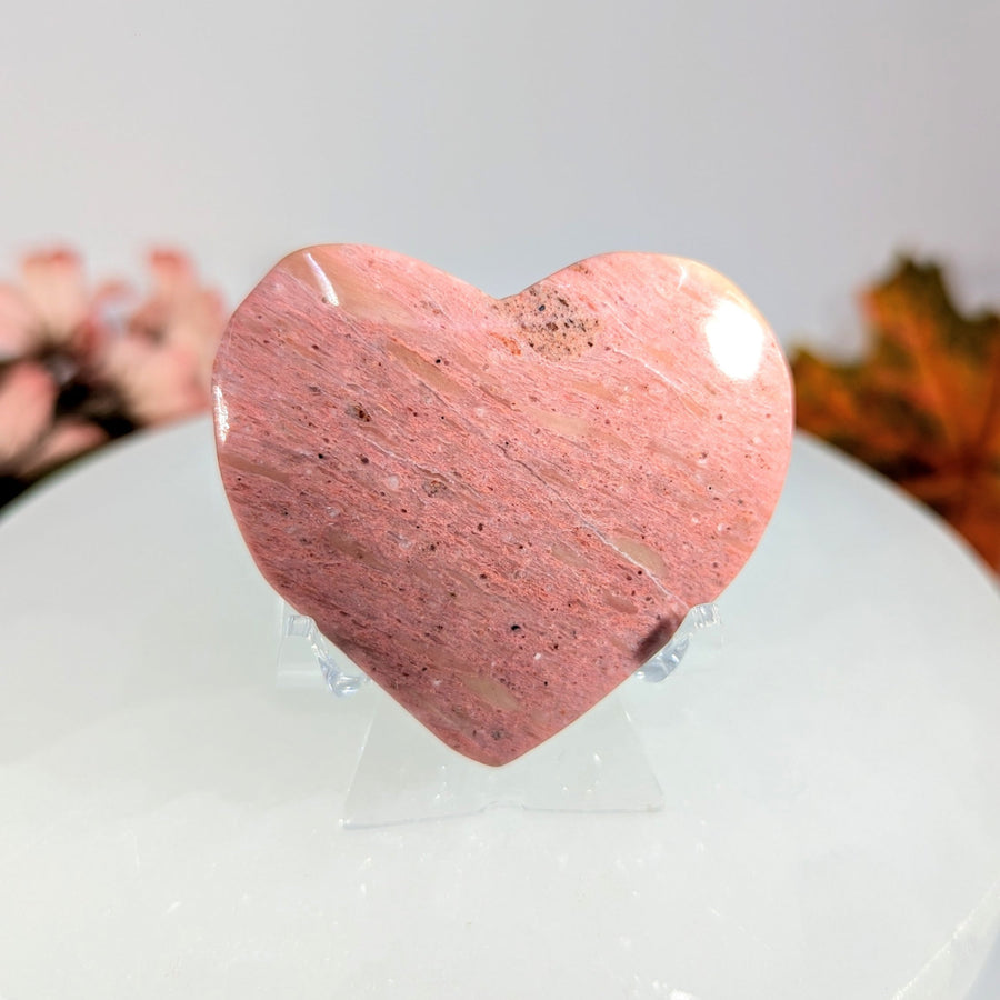 Pink rhodonite heart-shaped stone on display stand BC0093