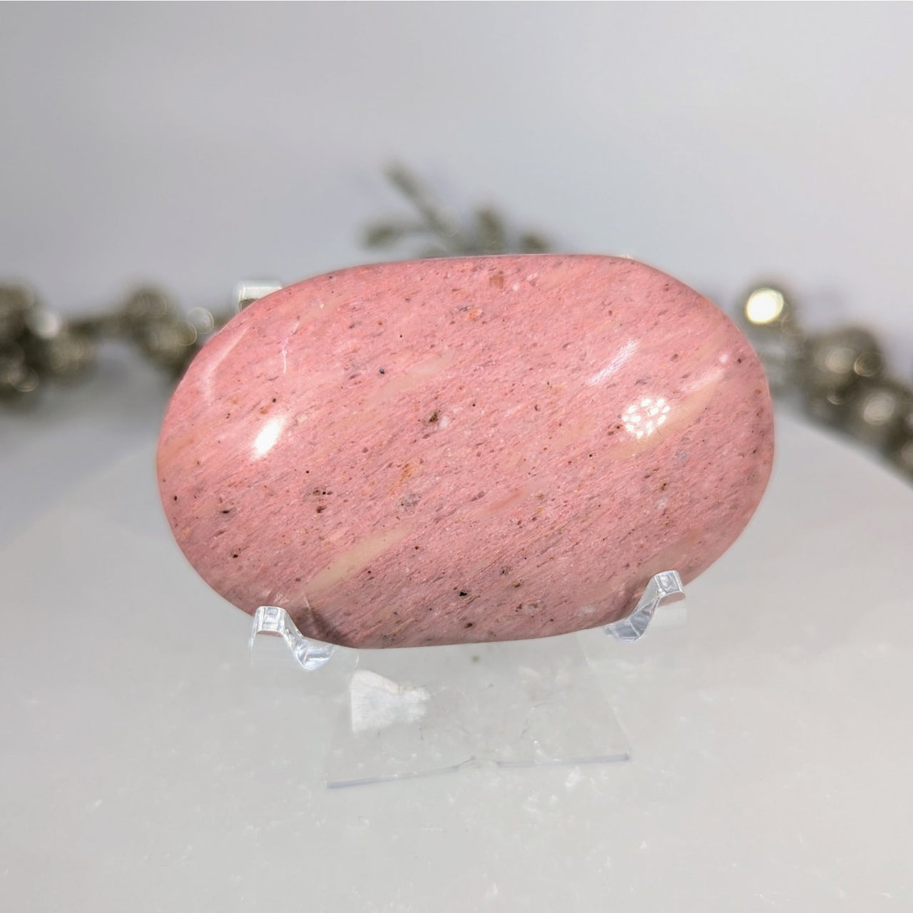 Pink speckled petrified wood 2.3-inch palm stone #BC0106 on display