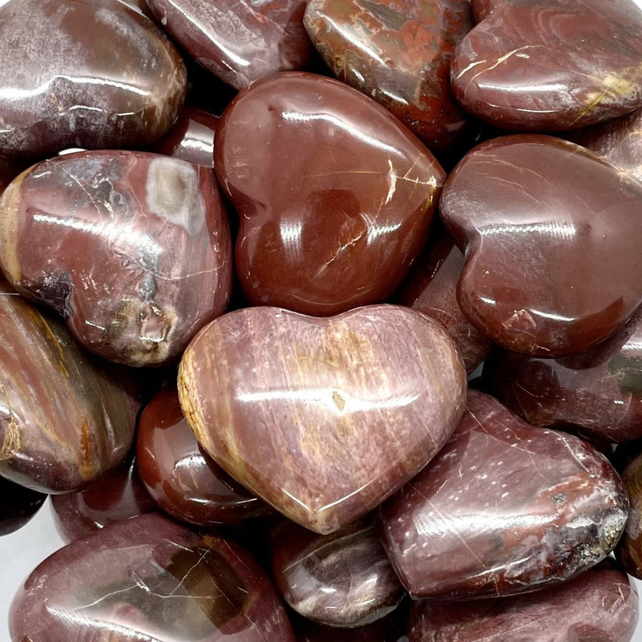 Polished petrified wood heart in deep reddish-brown tones, perfect for decor