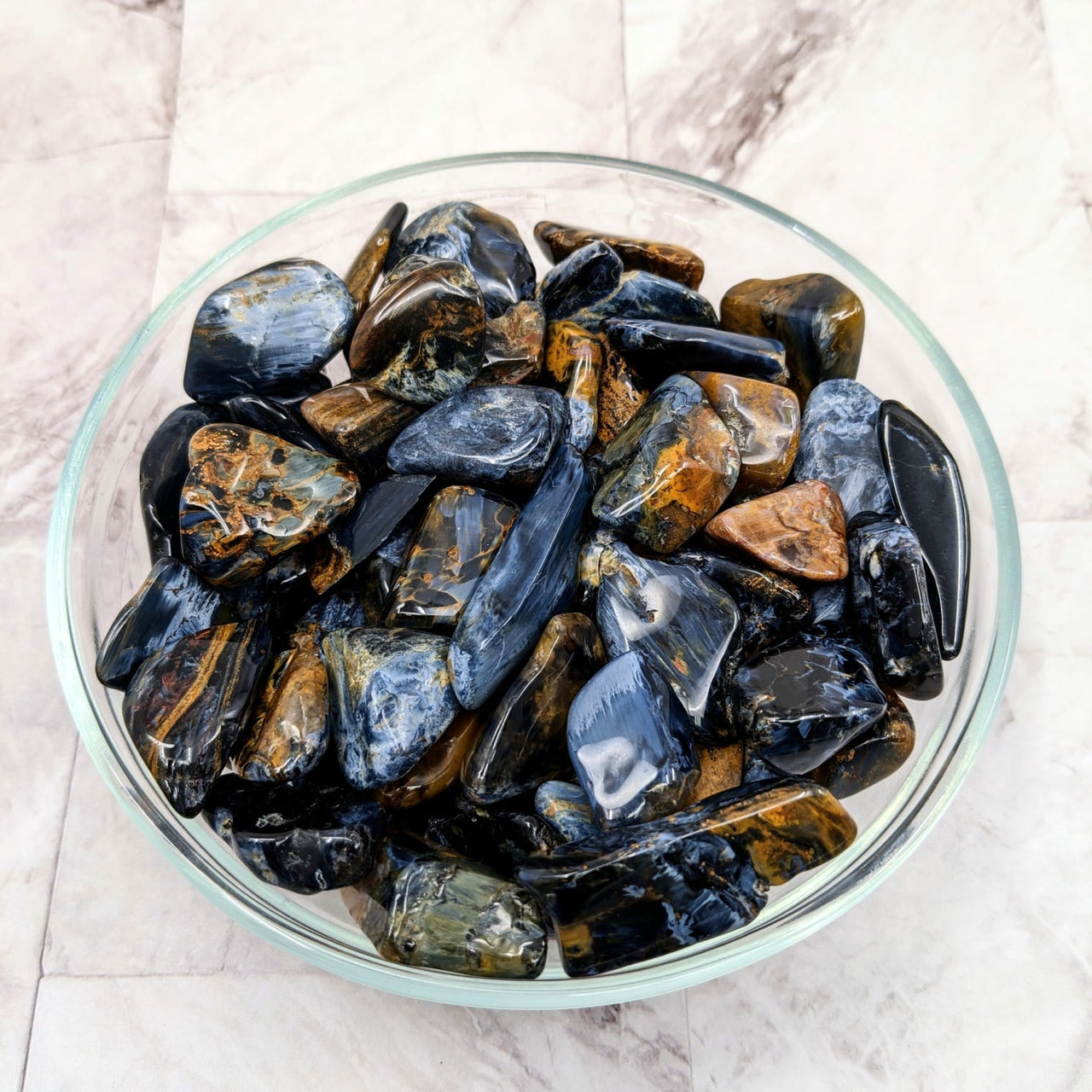 A bowl of musselins beside Pietersite Tumble Stone (1-1.5’) #LV2274 tumbled stones