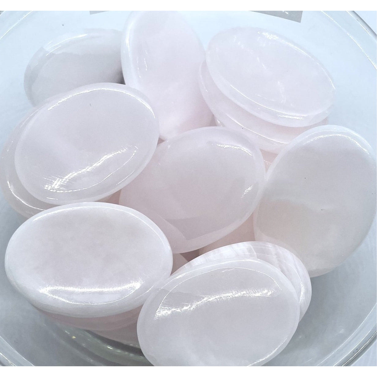 White glossy soap bars beside Pink Calcite Thumb Stone #P136 for soothing vibes