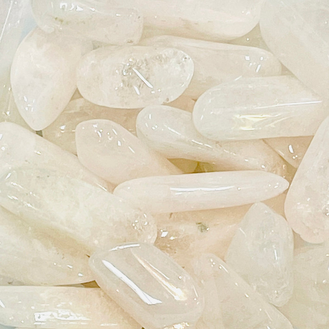 Polished white quartz crystals enhance Pink Danburite Tumbled #T444’s milky translucence