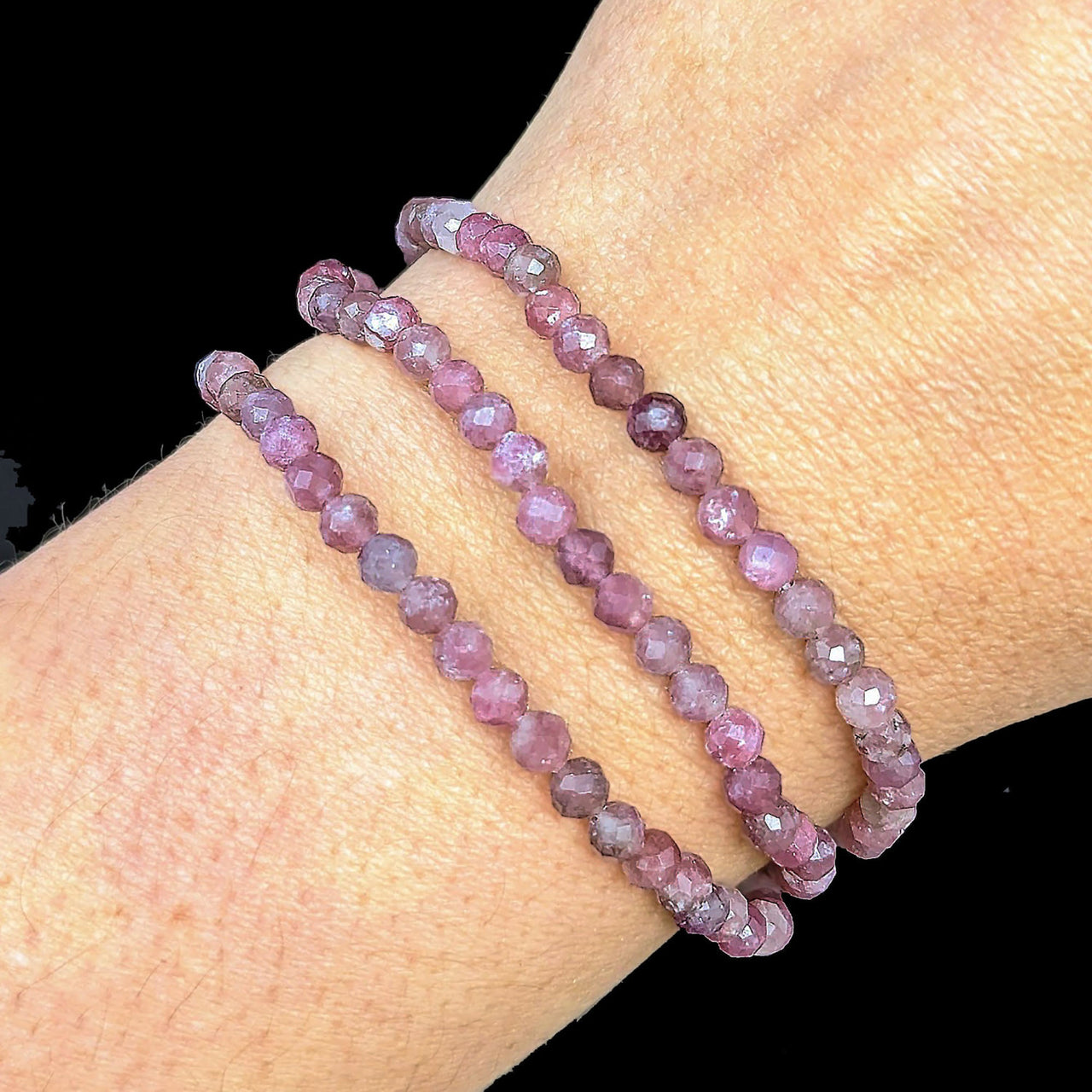 A woman’s hand wearing a Pink Tourmaline 7’ Faceted 4mm Bracelet #LV1842