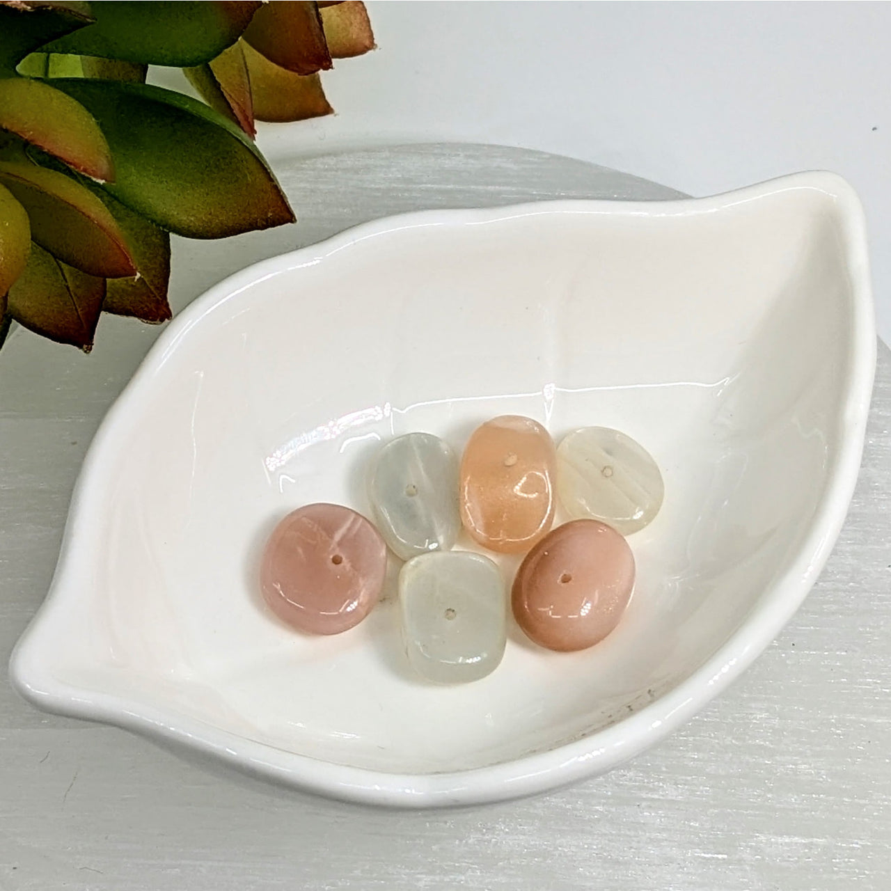 White leaf-shaped dish with pink and clear polished stones and 7mm moonstone beads