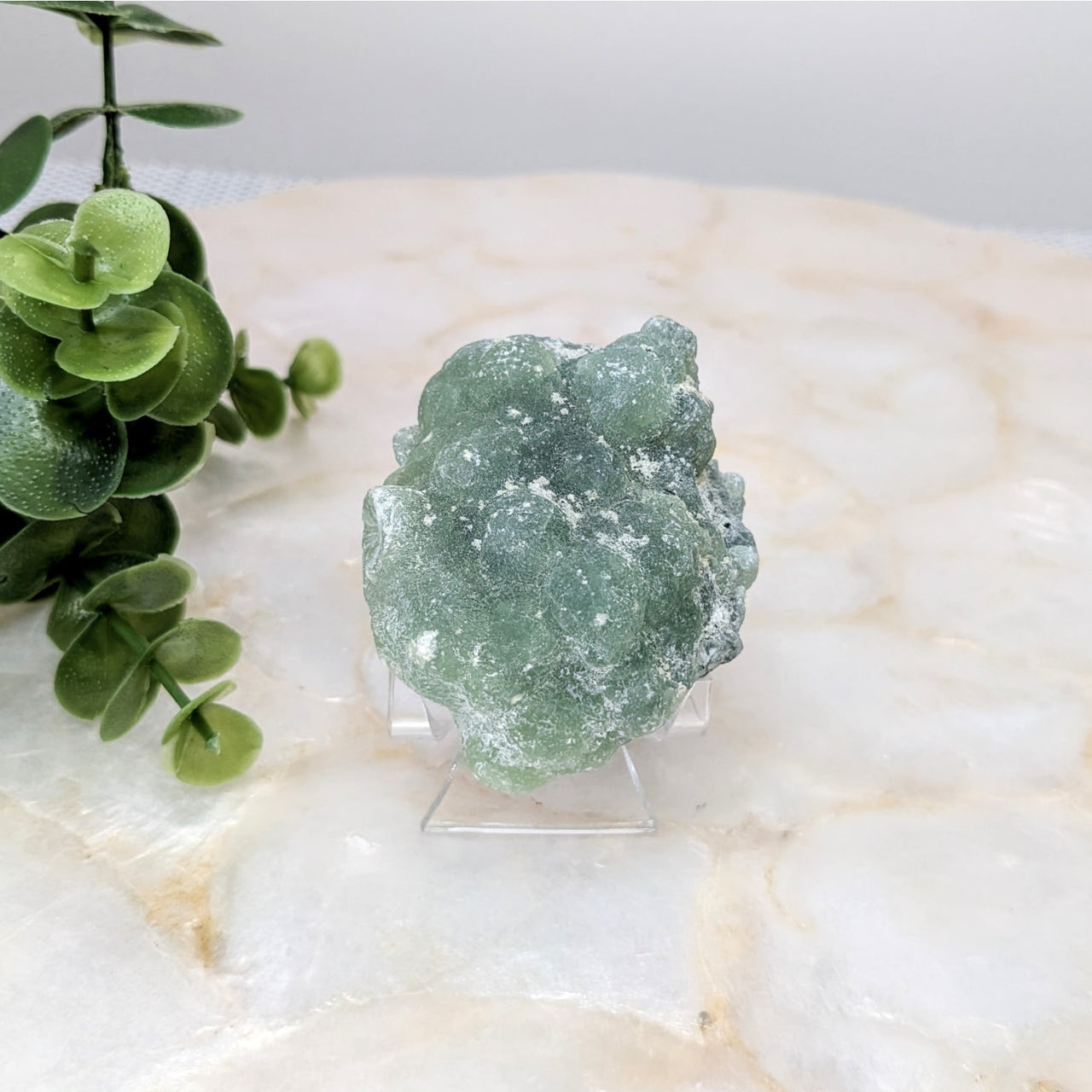 Close up of a Prehnite 2.5’ rough crystal specimen on a marble table