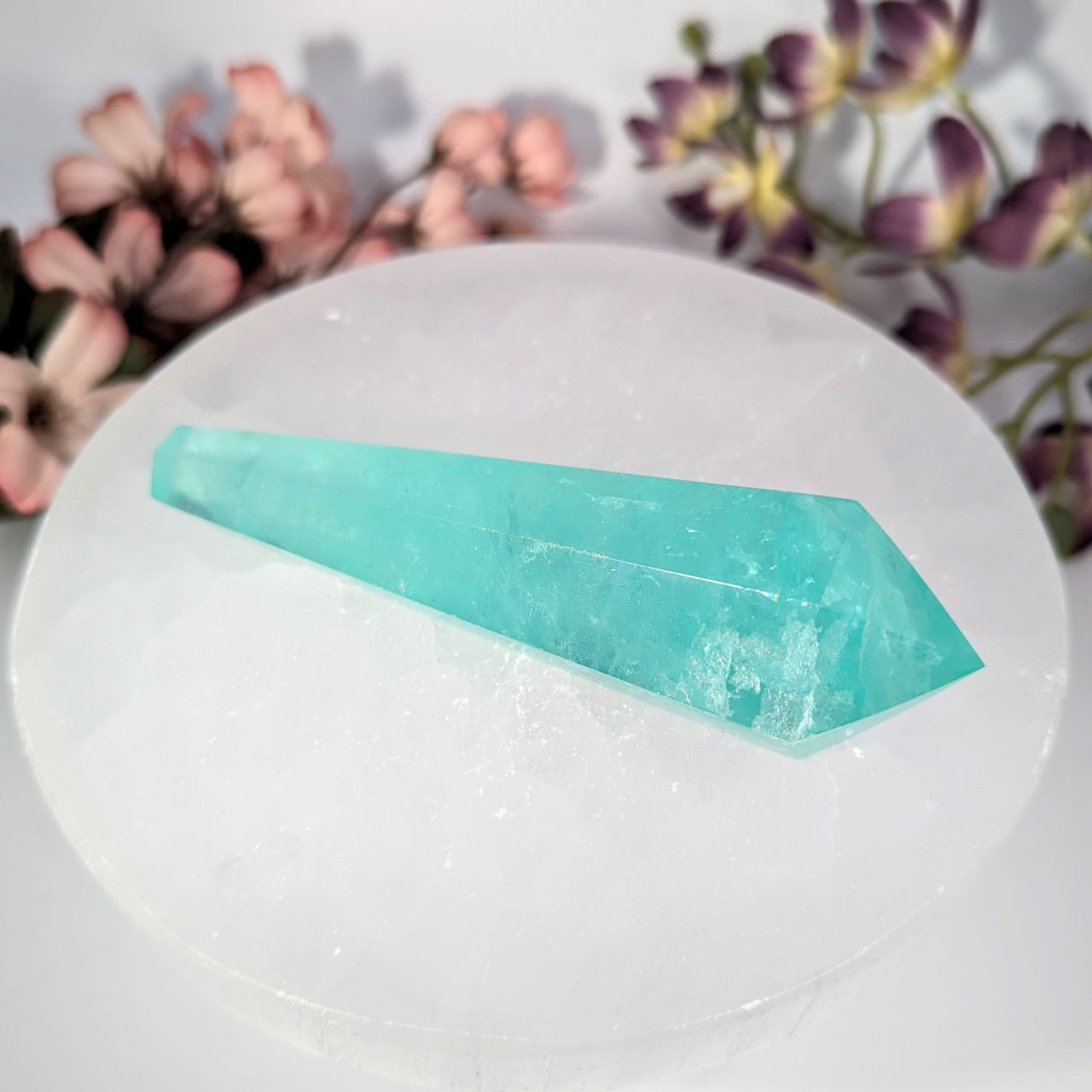 Aquamarine crystal wand on white selenite plate with floral accents