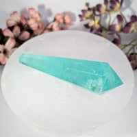 Aquamarine crystal wand on white selenite plate with floral accents