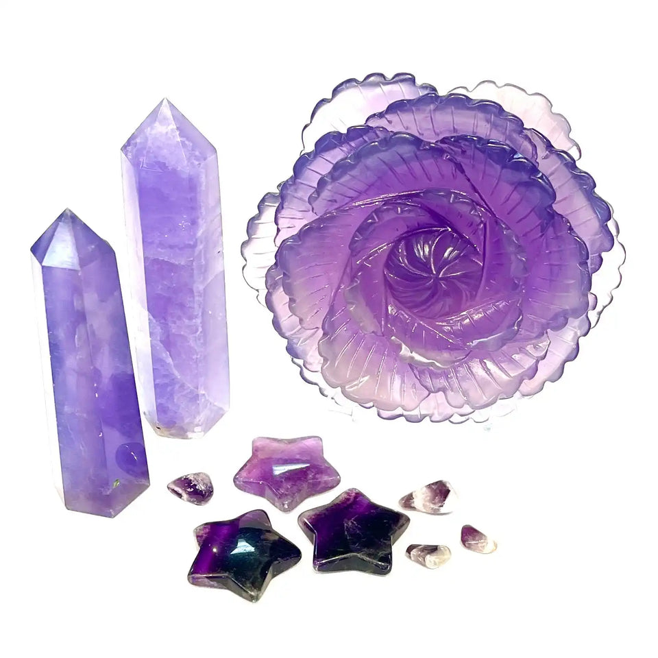 Purple crystals and gemstones arranged with a spiral-shaped ornament.