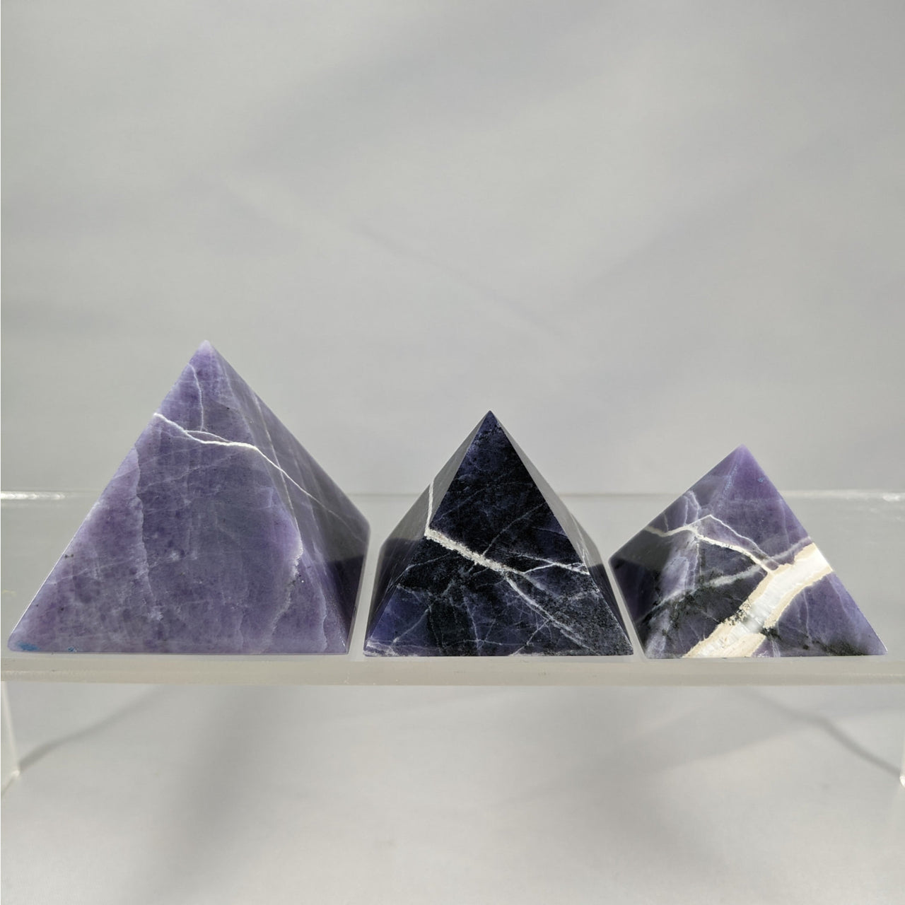 Three purple opal pyramids in black tones showcased in Purple Opal Pyramid N065