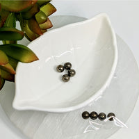 Thumbnail for White leaf-shaped ceramic dish holding Pyrite 6mm round beads for crafting projects