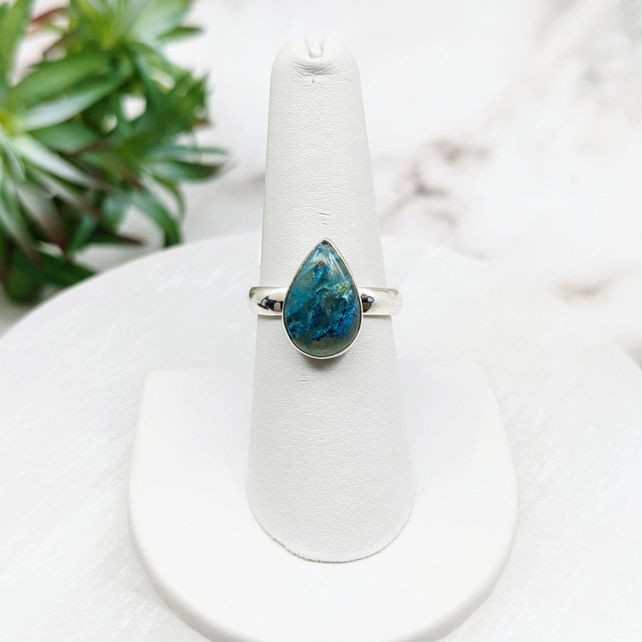 Quantum Quattro Sz. 8 SS Teardrop Ring: Stunning blue stone ring on a white stand #LV5002