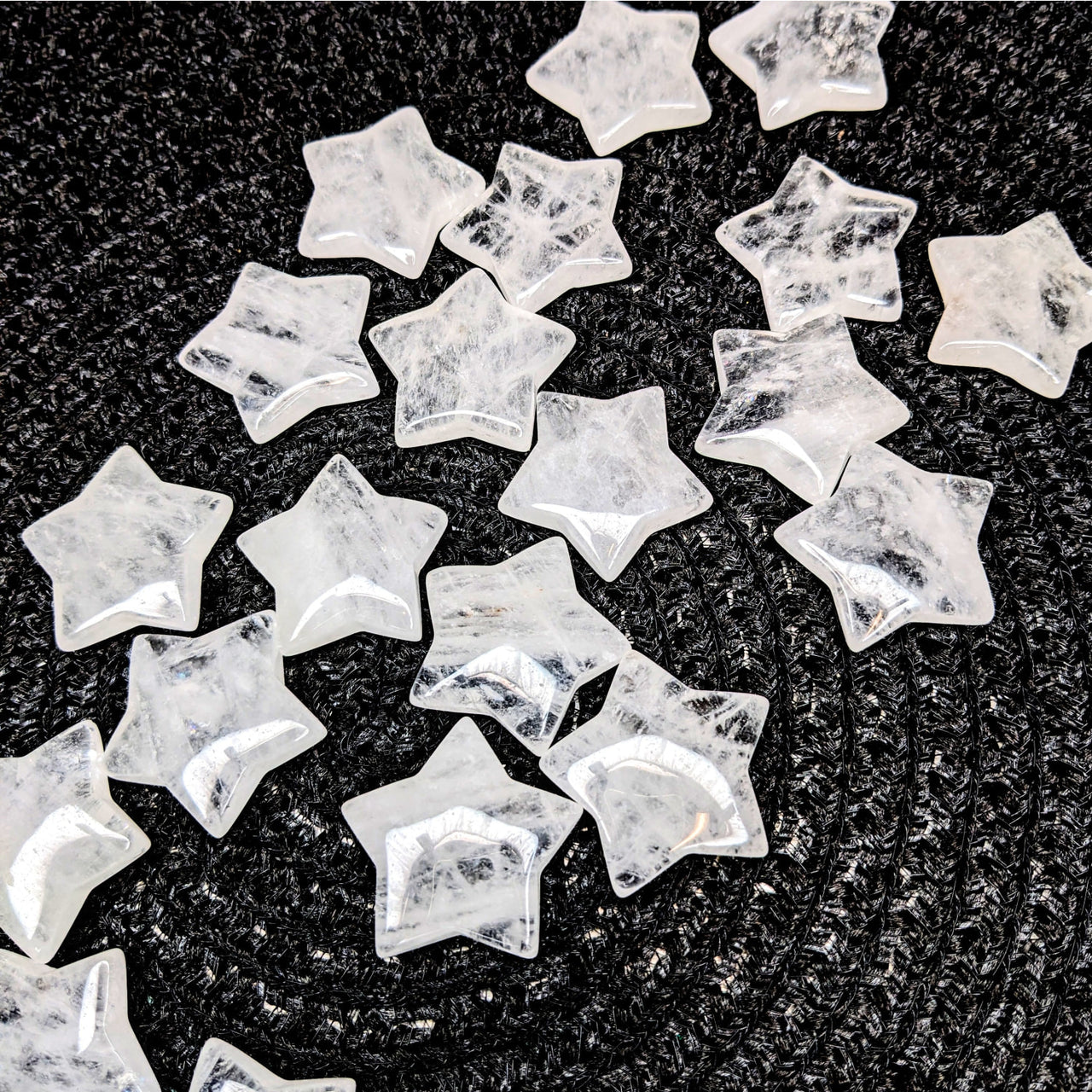 A pile of white marble stars on a black background - Quartz Star #LV3985, clear quartz crystal