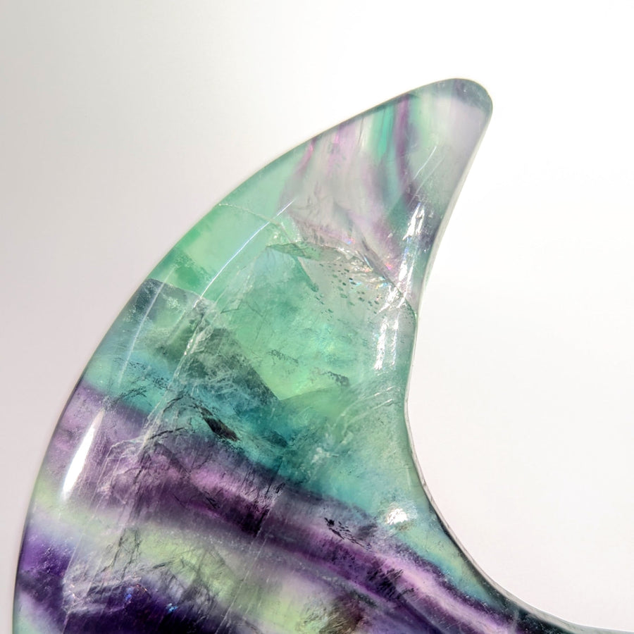 Translucent rainbow fluorite 4-inch moon geode with vibrant green purple bands, damaged tip