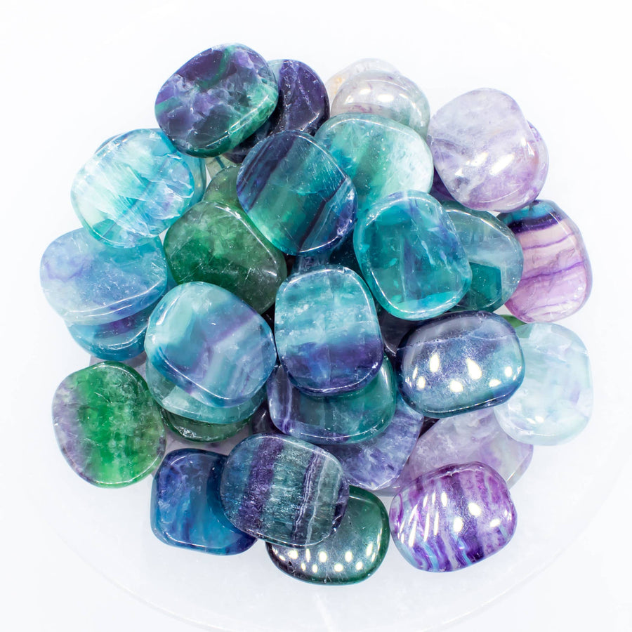 Pile of polished multicolored fluorite stones labeled Rainbow Fluorite Smooth Mini Palm LV7393
